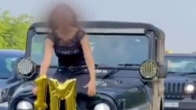 women sits on SUV bonnet