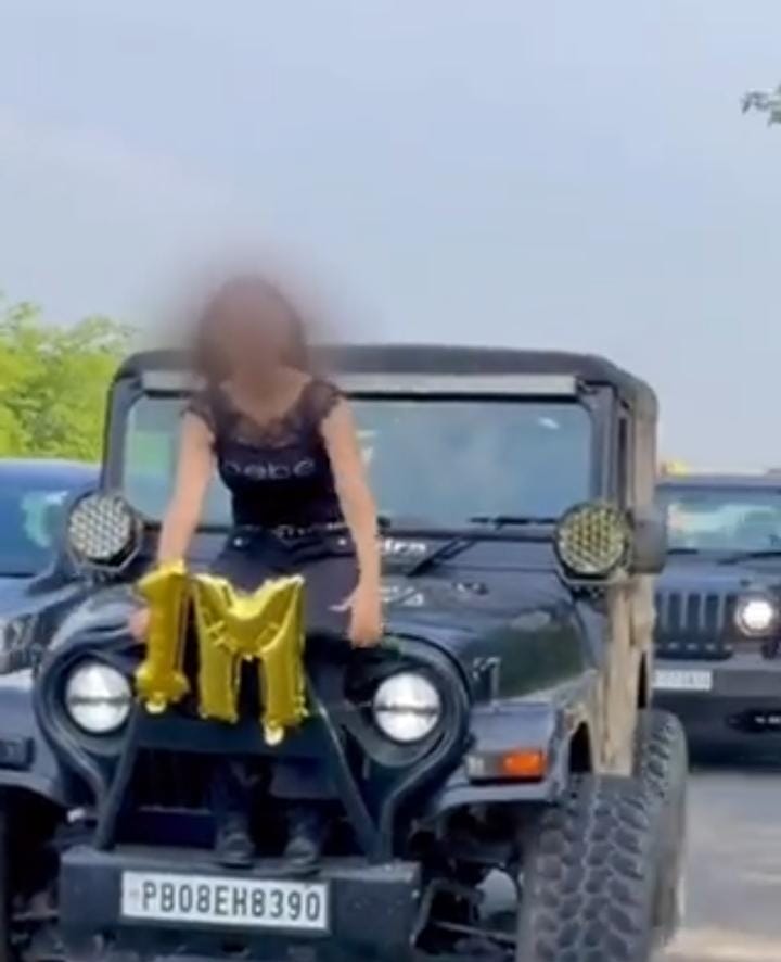 women sits on SUV bonnet